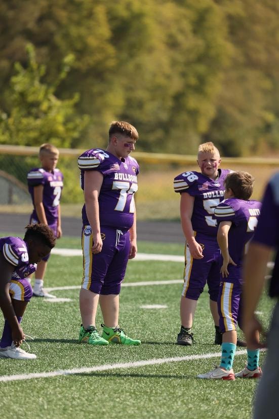 Brayden Wilson football players standing on the field